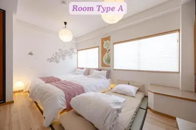 two beds in a room with a couch at Sakura Hotel Koiwa in Tokyo