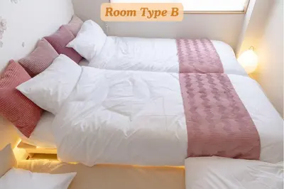 a bed with a white comforter and pillows at Sakura Hotel Koiwa in Tokyo