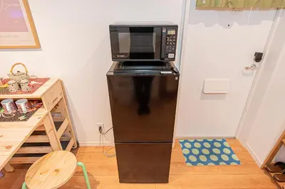 a microwave on top of a refrigerator in a room at 2 min walking distance to station cozy room in central tokyo in Tokyo