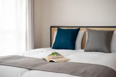 a book on a bed with a plant on it at \u30e6\u30ca\u30a4\u30c6\u30c3\u30c9\u30b0\u30ed\u30fc\u7530\u7aef\u65b0\u753a in Tokyo