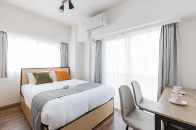 a bedroom with a bed and a desk and window at \u30e6\u30ca\u30a4\u30c6\u30c3\u30c9\u30b0\u30ed\u30fc\u7530\u7aef\u65b0\u753a in Tokyo