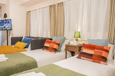 a living room with two beds and a tv at Mi-HOTEL UENO IRIYA in Tokyo