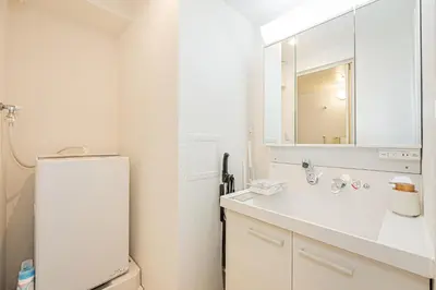 a white bathroom with a sink and a mirror at Mi-HOTEL UENO IRIYA in Tokyo