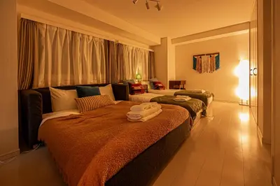 a hotel room with two beds and a couch at Mi-HOTEL UENO IRIYA in Tokyo