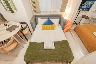 a small room with a bed and a table at Mi-HOTEL UENO IRIYA in Tokyo