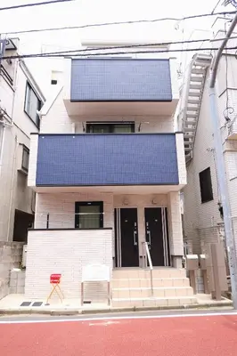 a house with a blue roof on a street at Mi-Villa Aprire Yotsuya in Tokyo