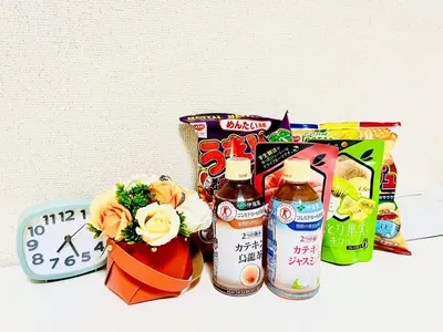 a bunch of food and drinks on a table with a clock at \u9326\u7cf8\u753a-502 in Tokyo