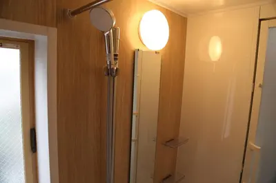 a bathroom with a refrigerator and a light on the wall at Km101 \u4e0a\u6c60\u888b in Tokyo
