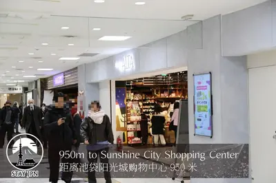 a group of people walking through a shopping center at Km102\u4e0a\u6c60\u888b in Tokyo