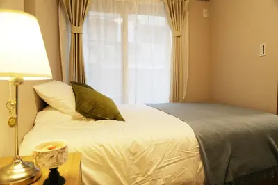 a bedroom with a bed with a window and a lamp at Km102\u4e0a\u6c60\u888b in Tokyo