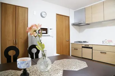 a kitchen with a vase of flowers on a table at Km201\u4e0a\u6c60\u888b in Tokyo