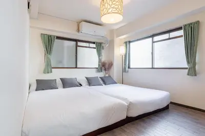 a bedroom with a large white bed with windows at o\u30d3\u30eb301 in Tokyo
