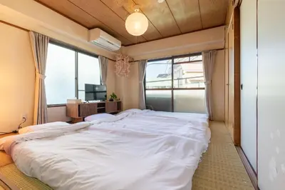 a large white bed in a room with windows at o\u30d3\u30eb301 in Tokyo