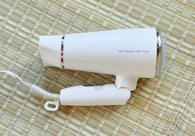 a white hair dryer sitting on a carpet at o\u30d3\u30eb301 in Tokyo