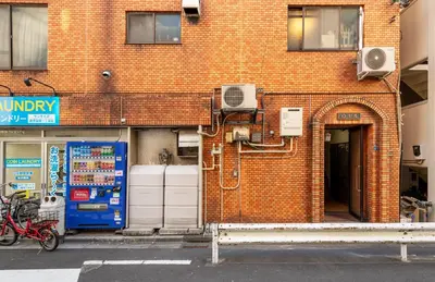 a brick building with an open door with a fan at o\u30d3\u30eb301 in Tokyo