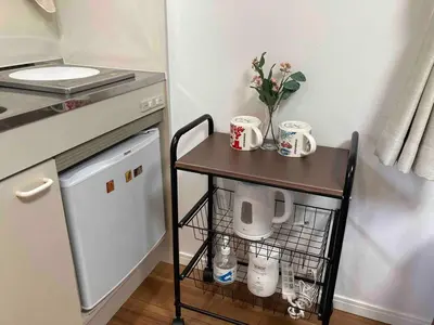 a small table with mugs and flowers on it in a kitchen at 103\u53f7 \u5c71\u624b\u7ebf\u8fd1\u4e0a\u91ce\u4e00\u7ad9\u6e29\u99a8\u65b0\u516c\u5bd3 in Tokyo