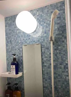 a bathroom with a shower with a light and a mirror at 103\u53f7 \u5c71\u624b\u7ebf\u8fd1\u4e0a\u91ce\u4e00\u7ad9\u6e29\u99a8\u65b0\u516c\u5bd3 in Tokyo