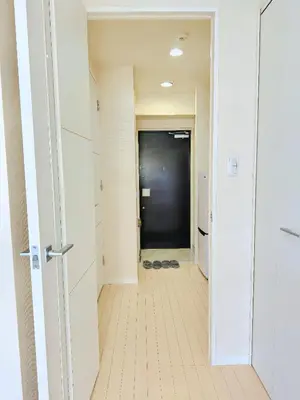 a hallway with a door leading to a hallway with shoes at \u9326\u7cf8\u753a-601 in Tokyo