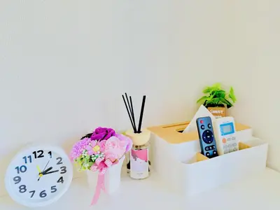 a table with a clock and flowers and other items at \u9326\u7cf8\u753a-601 in Tokyo