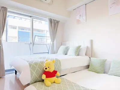 a yellow teddy bear sitting on a couch in a bedroom at \u9326\u7cf8\u753a-601 in Tokyo