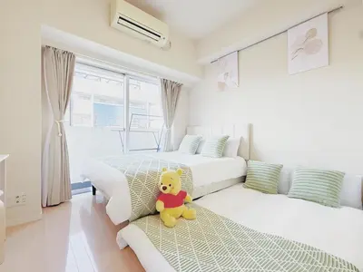 a teddy bear sitting on a bed in a bedroom at \u9326\u7cf8\u753a-601 in Tokyo