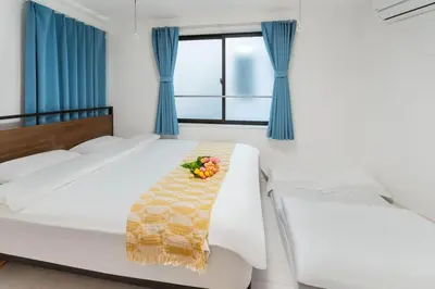 a bedroom with a bed with a bowl of fruit on it at 5 min walk from Gotanno station 20sqm apartment with private toilet and bathroom Direct access to popular travel destinations such as Ueno in Tokyo