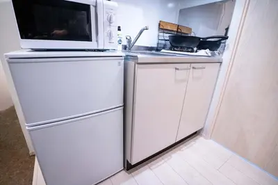 a kitchen with a microwave on top of a refrigerator at 5 min walk from Gotanno station 20sqm apartment with private toilet and bathroom Direct access to popular travel destinations such as Ueno in Tokyo
