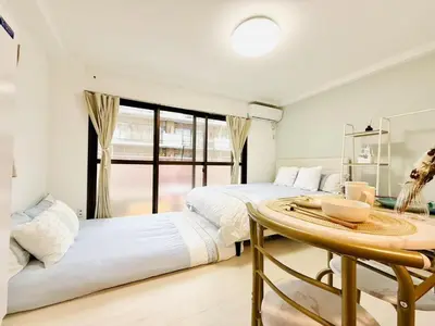 two beds in a room with a table and a window at SkyTree-402 in Tokyo