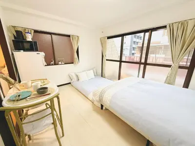 a bedroom with two beds and a table and a window at SkyTree-402 in Tokyo