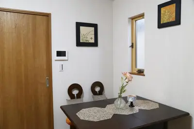 a dining room table with a vase of flowers on it at Km301\u4e0a\u6c60\u888b in Tokyo