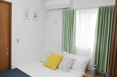 a bedroom with a bed with green and white curtains at Km302\u4e0a\u6c60\u888b in Tokyo
