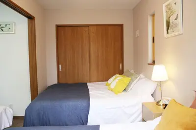 a bedroom with a bed with a yellow pillow on it at Km302\u4e0a\u6c60\u888b in Tokyo