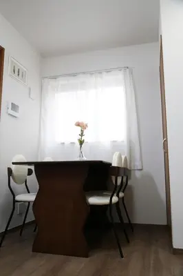 a dining room table and chairs in front of a window at Km302\u4e0a\u6c60\u888b in Tokyo