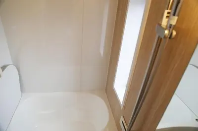 a bathroom with a toilet and a door with a window at Km302\u4e0a\u6c60\u888b in Tokyo