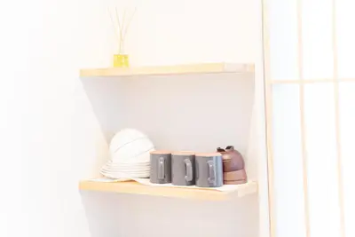 a shelf in a kitchen with plates and utensils at Hotel Shitamachi Place Asakusa in Tokyo