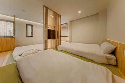two beds in a room with white sheets at Hotel Shitamachi Place Asakusa in Tokyo