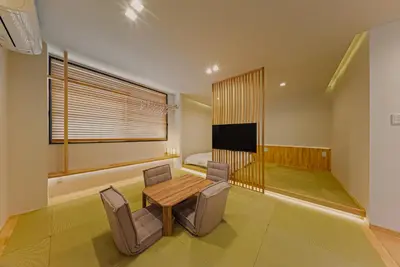 a room with a table and chairs and a bed at Hotel Shitamachi Place Asakusa in Tokyo