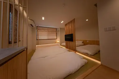 a bedroom with two beds and a tv in it at Hotel Shitamachi Place Asakusa in Tokyo