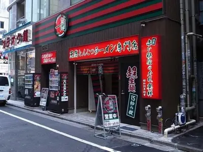 a store with red signs on the side of a street at \u65b0\u5bbf\u306e\u4e00\u8ed2\u5bb6 90\u5e73\u7c73 \u99d0\u8eca\u5834\u4ed8 3\u5bdd\u5ba47\u30d9\u30c3\u30c9 \u6771\u65b0\u5bbf\u99c5\u5f92\u6b699\u5206 in Tokyo
