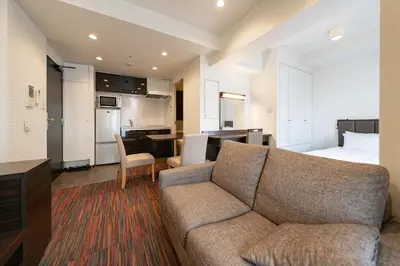 a living room with a couch and a bedroom at APA SERVICED RESIDENCE SHINJUKU by unito in Tokyo