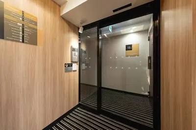 a hallway with a glass door in a building at APA SERVICED RESIDENCE SHINJUKU by unito in Tokyo