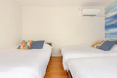 two twin beds in a room with white walls at jtr\u65b0\u5c0f\u5ca92\u4e01\u76ee in Tokyo