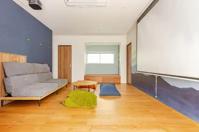 a living room with a couch and a projection screen at jtr\u65b0\u5c0f\u5ca92\u4e01\u76ee in Tokyo