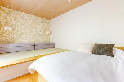 a bedroom with a white bed and a wall at jtr\u65b0\u5c0f\u5ca92\u4e01\u76ee in Tokyo
