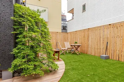 a small garden with a wooden fence and a table at jtr\u65b0\u5c0f\u5ca92\u4e01\u76ee in Tokyo