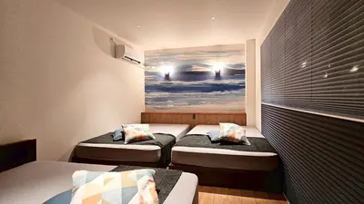 a room with two beds and a painting on the wall at jtr\u65b0\u5c0f\u5ca92\u4e01\u76ee in Tokyo