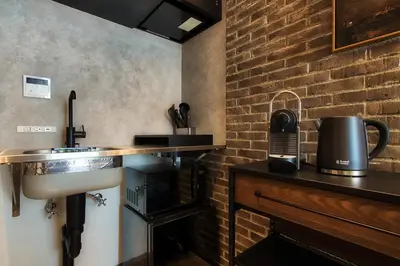 a kitchen with a sink and a brick wall at STUMP SA MinamiAzabu in Tokyo