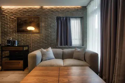 a living room with a couch and a brick wall at STUMP SA MinamiAzabu in Tokyo