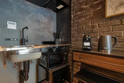 a kitchen with a sink and a brick wall at STUMP SA MinamiAzabu in Tokyo