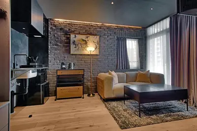 a living room with a couch and a brick wall at STUMP SA MinamiAzabu in Tokyo